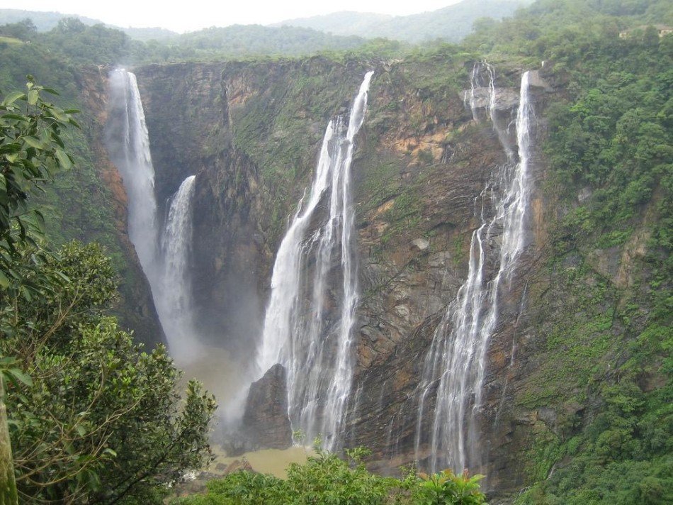 A waterfall through forested cliffs